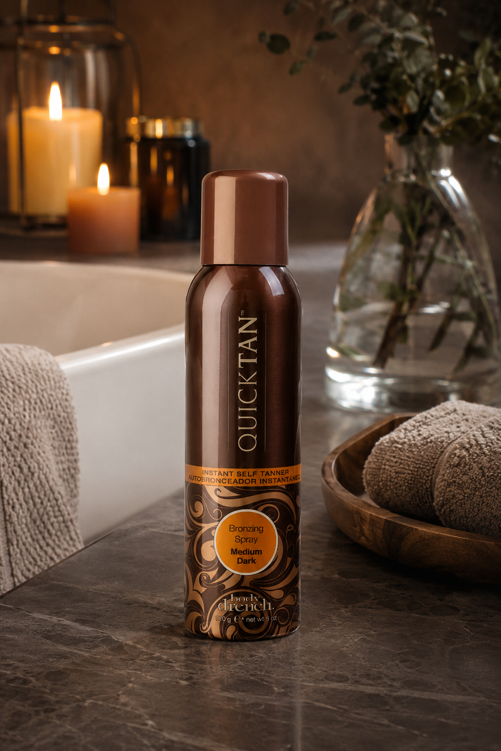 Body Drench Quick Tan Medium Dark self-tanner bronzing spray on a warm stone vanity.