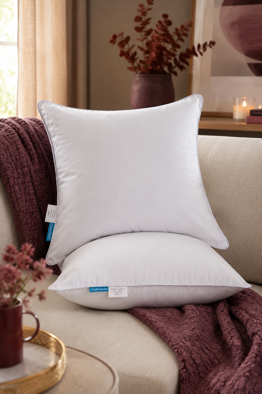 Two white Oubonun 18x18 throw pillow inserts styled on an oyster sofa with plum accents.