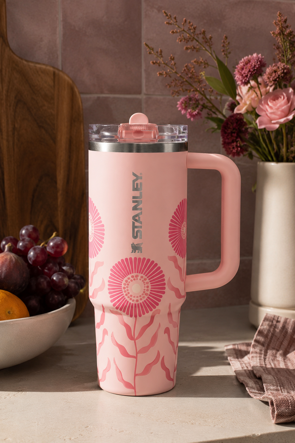Pink STANLEY Quencher ProTour 30 oz tumbler with floral design and handle displayed on a kitchen counter.